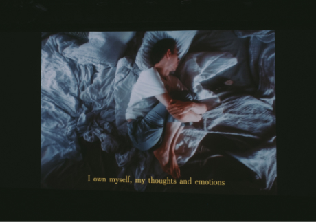 Кадр из фильма программы: человек на кровати, субтитры I own myself, my thoughts and emotions